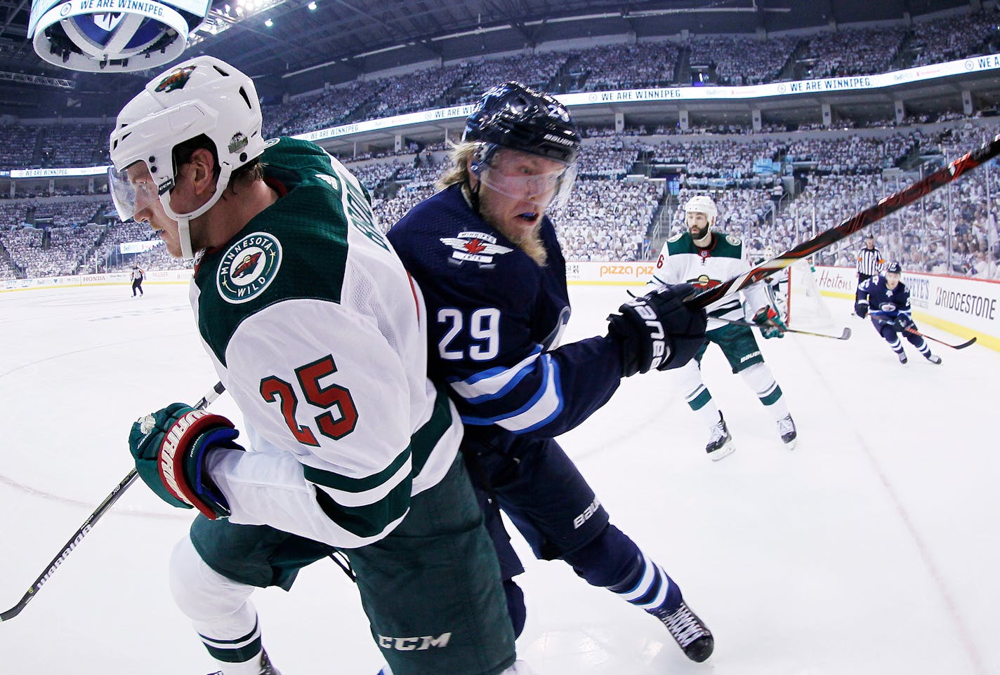 Winnipeg Jets' Patrik Laine (29) checks Minnesota Wild's Jonas Brodin (25) during the second period of Game 1 in an NHL hockey first-round playoff series Wednesday, April 11, 2018, in Winnipeg, Manitoba. (John Woods/The Canadian Press via AP)