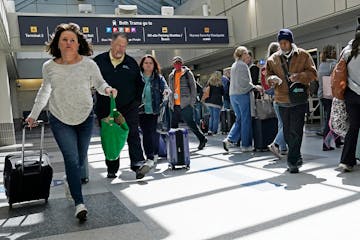 Travelers walk through the Minneapolis-St. Paul International Airport in April. Travel is roaring back this year. 