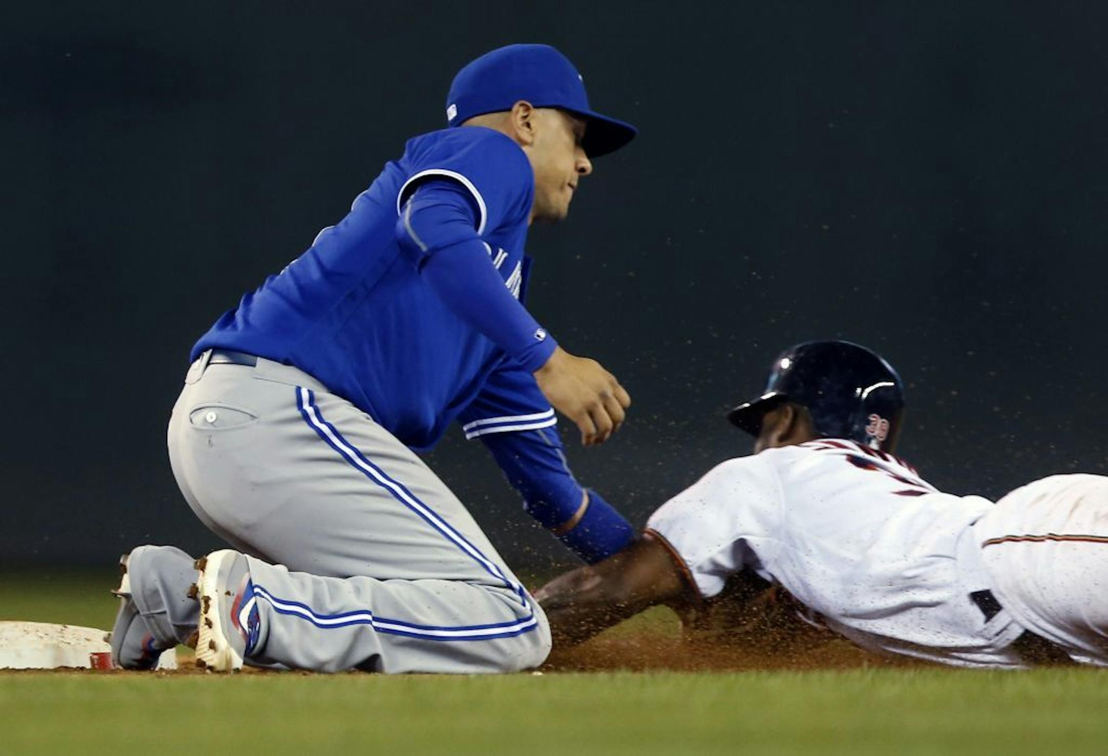 Toronto Blue Jays second baseman Ryan Goins, left, tags out Minnesota Twins' Danny Santana on an attempted steal of second base during the 11th inning of a baseball game Thursday, May 19, 2016, in Minneapolis. The Blue Jays won 3-2 in 11 innings.