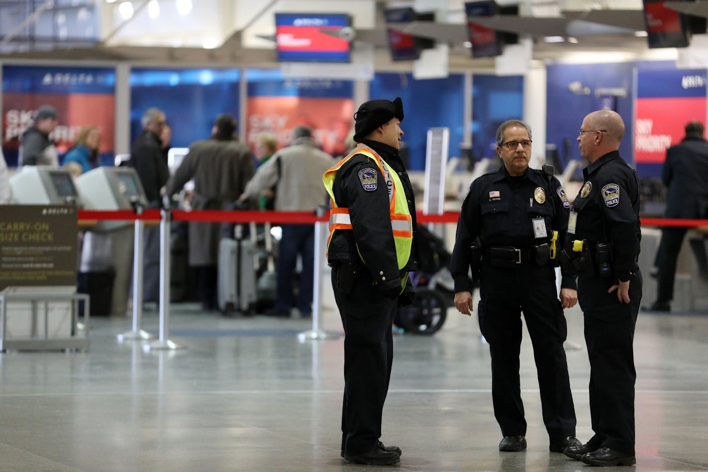 A group of police officers stood near the Delta ticketing counter Saturday.