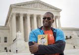 In this Oct. 13, 2017, photo, Bryant Johnson, personal trainer for Supreme Court Justice Ruth Bader Ginsburg poses in Washington, with his new book, "The RBG Workout: How She Stays Strong ... and You Can Too!" Besides the 84-year-old Ginsberg, Johnson, who now also trains Justice Stephen Breyer and Justice Elena Kagan. Johnson says he hopes the book will help convince people: &#xec;You&#xed;re never too old to do something.&#xee; (AP Photo/J. Scott Applewhite)