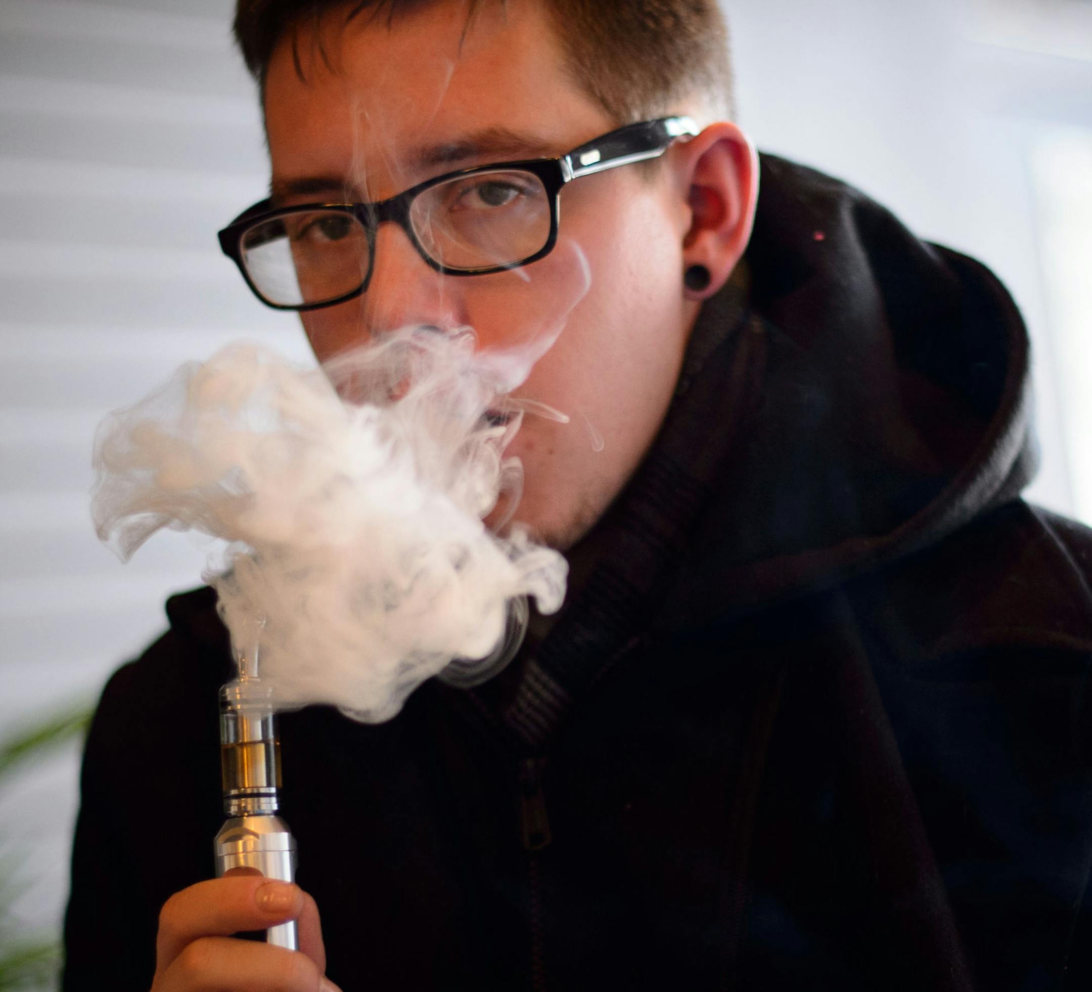 Where there’s smoke, no fire: E-cigarettes create a vapor that dissipates quickly. Lyle Newby tried a new flavor at Uptown Vapor Shop.