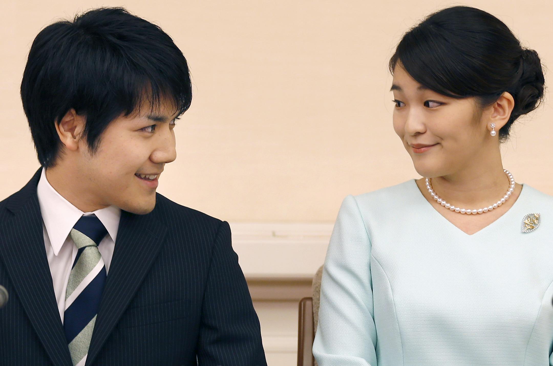 Japan's Princess Mako, right, the elder daughter of Prince Akishino and Princess Kiko, and her fiance Kei Komuro, look at each other during a press conference at Akasaka East Residence in Tokyo, Sunday, Sept. 3, 2017. Japanese Emperor Akihito's oldest grandchild, Princess Mako, says she is getting married to her university classmate who won her heart with bright smiles and sincerity.(AP Photo/Shizuo Kambayashi, Pool)