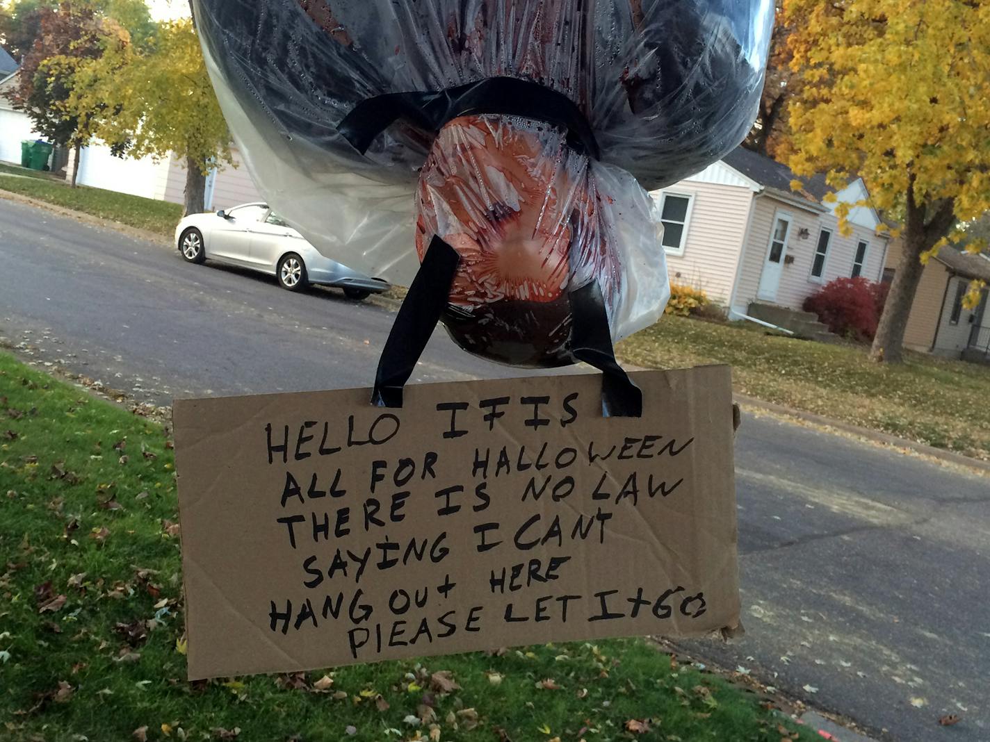 The realistic looking 'bodies' are wrapped in plastic and tape and hang from their feet in front of the St. Louis Park home.