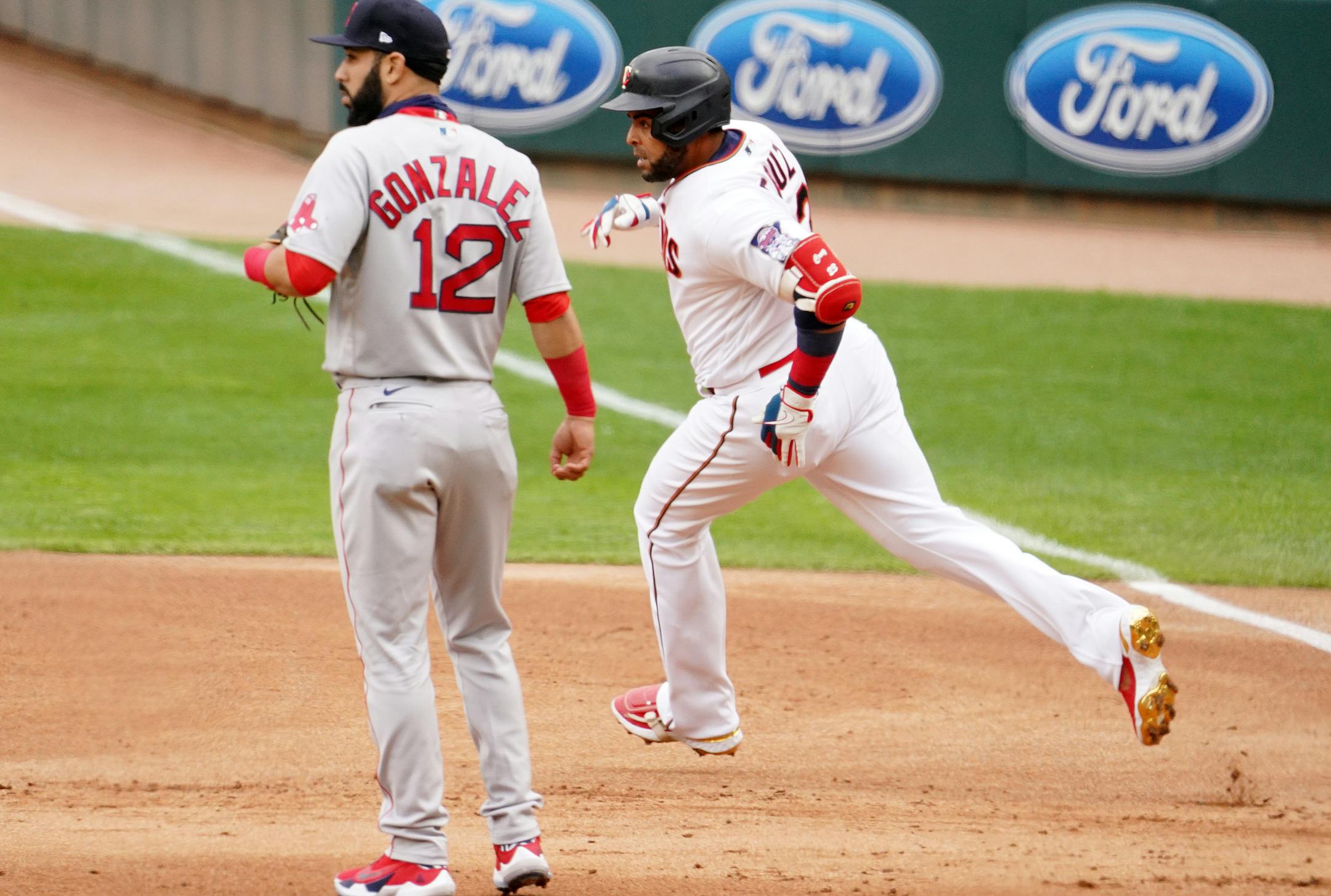 Minnesota Twins designated hitter Nelson Cruz (23) rounded first base past former Minnesota Twins player Boston Red Sox first baseman Marwin Gonzalez (12) after hitting a double in the first inning.