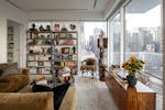 A bookshelf in the living room of interior designer Andrew Torrey's apartment on the Upper East Side of Manhattan displays art books and treasures fro