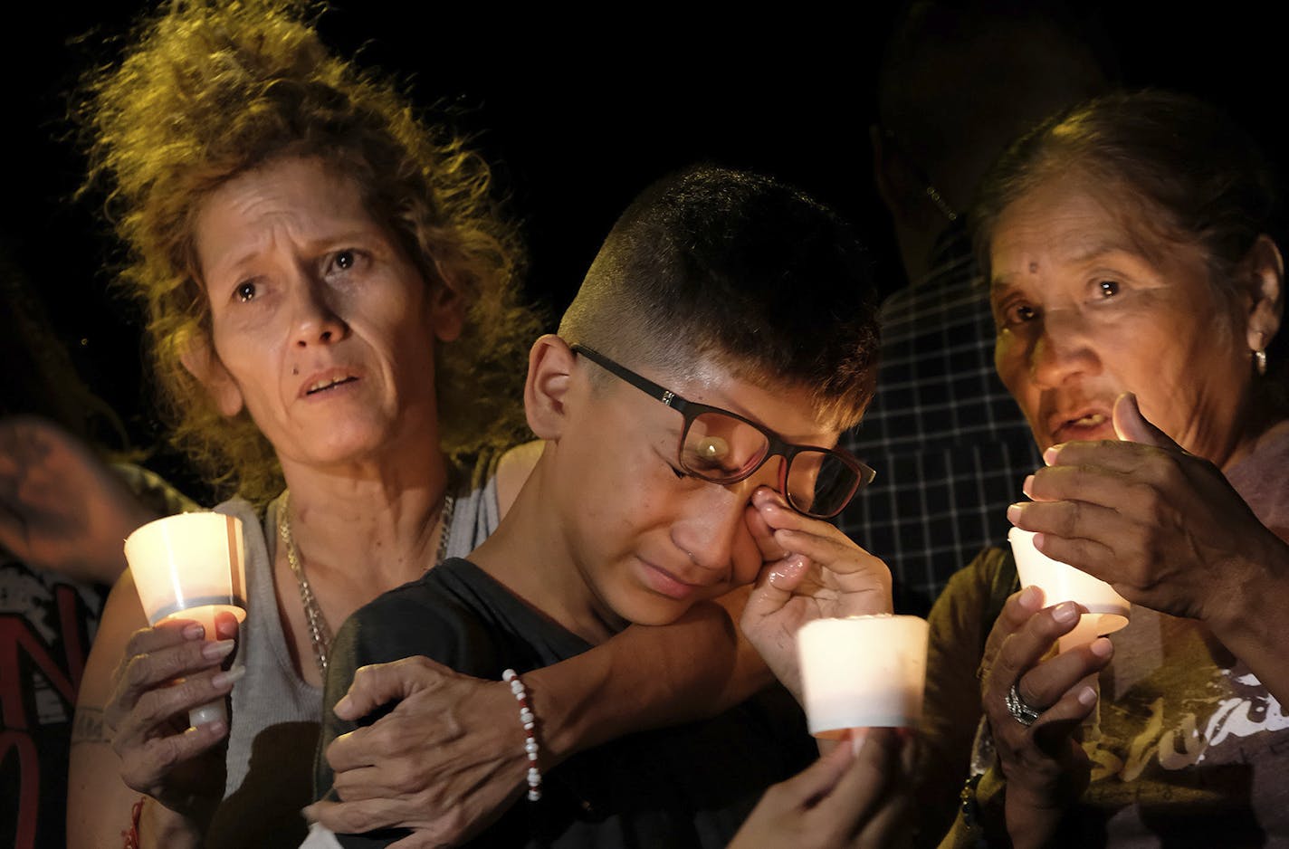 Mona Rodriguez, Jayanthony Hernandez, 12 and Juanita Rodriguez, from left, participate in a candlelight vigil held for the victims of a fatal shooting at the First Baptist Church of Sutherland Springs, Sunday, Nov. 5, 2017, in Sutherland Springs, Texas. (AP Photo/Laura Skelding) ORG XMIT: MIN2017110520564465