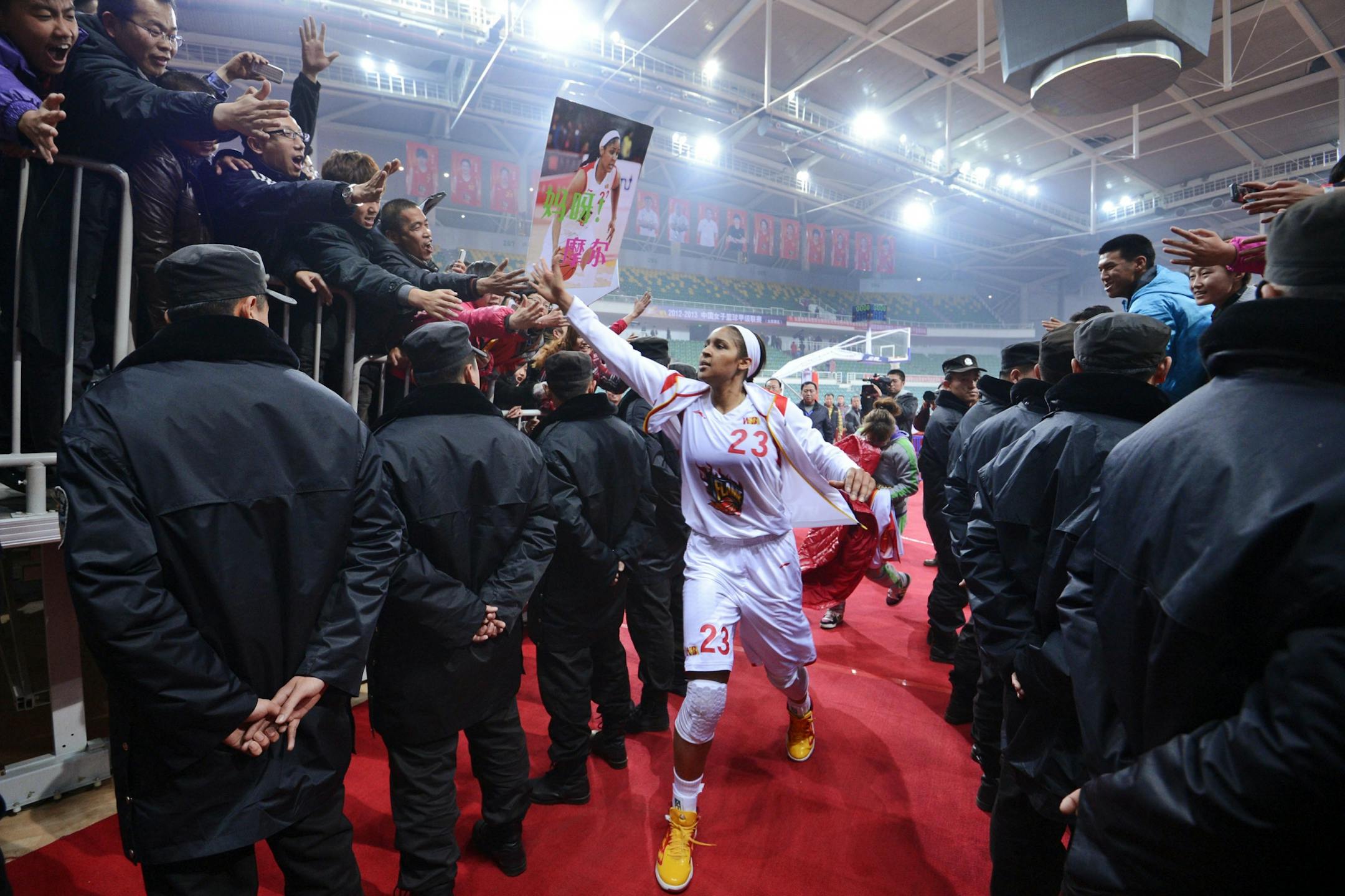 In this Nov. 24, 2012, photo, Shanxi Flame's Maya Moore greets fans as she prepares to take the court for a WCBA basketball game against the Jiangsu Dragons in Taiyuan, China.