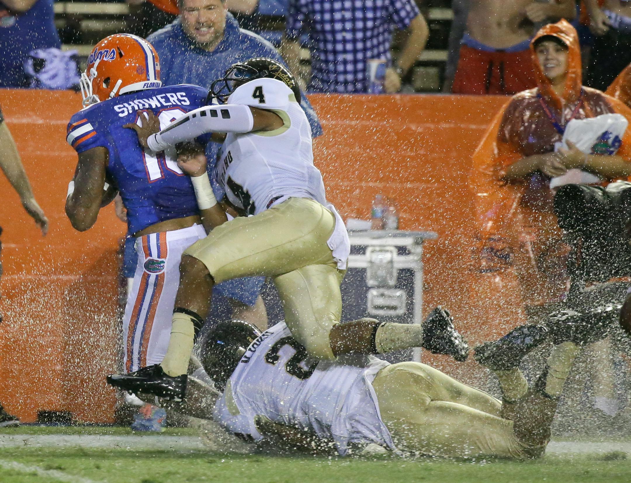 Florida's Valdez Showers, left, is forced out of bounds by Idaho cornerback Jayshawn Jordan (4) and safety Bradley Njoku (2) after a 66-yard kickoff return during the first half of an NCAA college football game in Gainesville, Fla., Saturday, Aug. 30, 2014. (AP Photo/John Raoux)