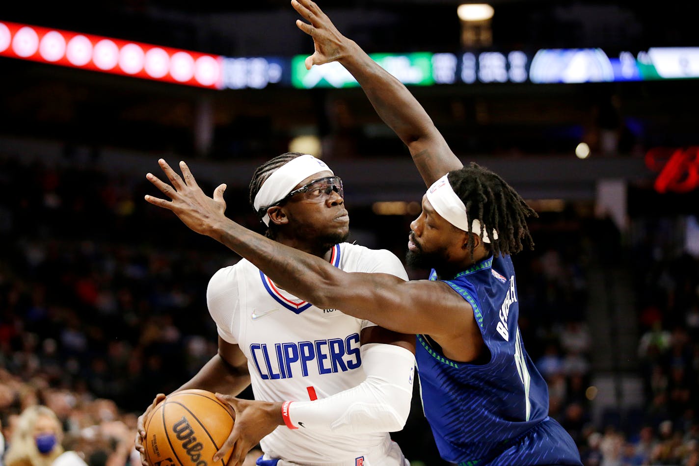 Clippers guard Reggie Jackson is guarded closely by Timberwolves guard Patrick Beverley during the first half