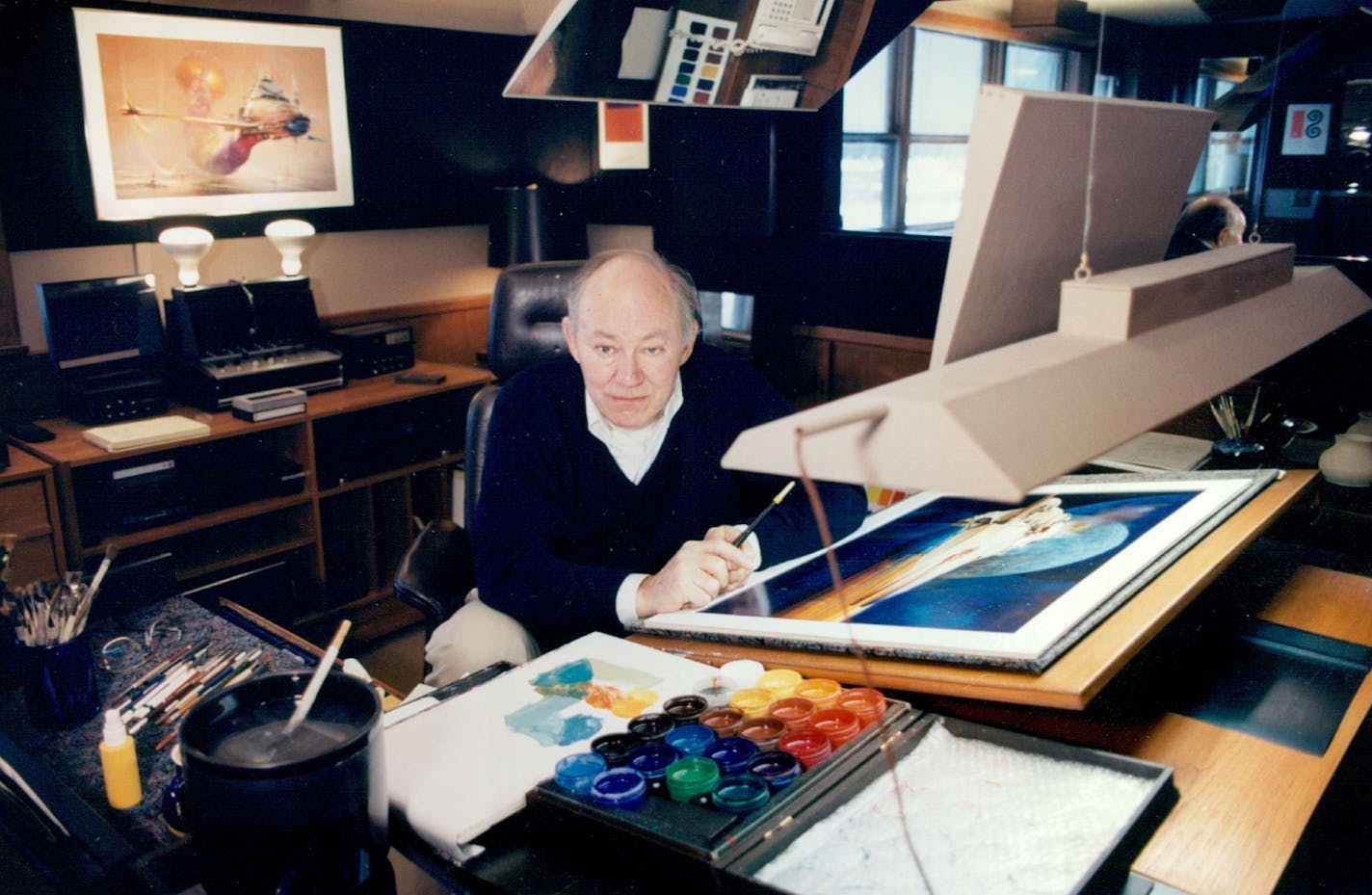 Artist John Berkey in his Excelsior home/studio in December 1991 with "A Change in Direction" on the desk. A two-way mirror let him see his work as it would appear from a distance.