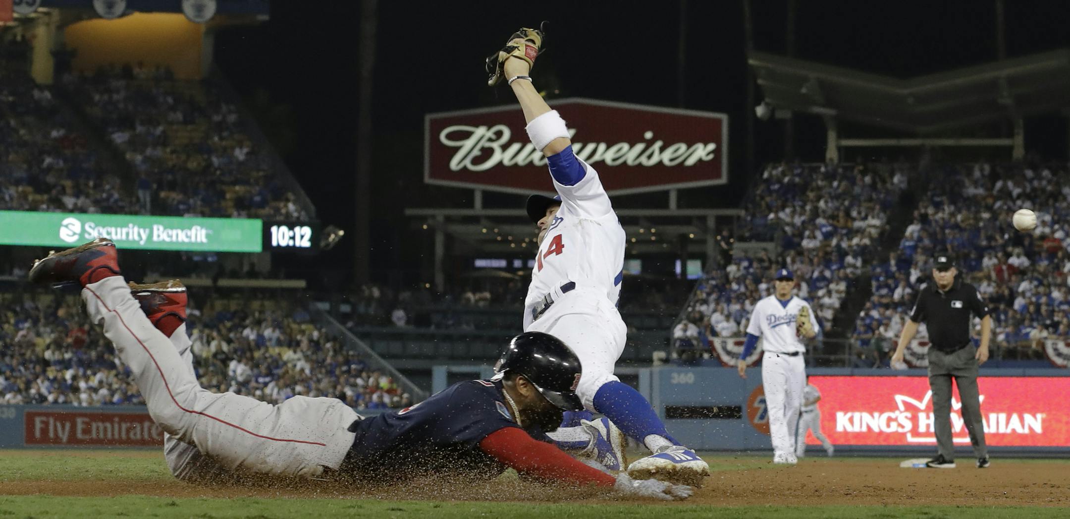 Boston Red Sox's Eduardo Nunez is safe at first past Los Angeles Dodgers first baseman Enrique Hernandez on a fielding error by relief pitcher Scott Alexander during the 13th inning in Game 3 of the World Series baseball game on Friday, Oct. 26, 2018, in Los Angeles. (AP Photo/David J. Phillip)