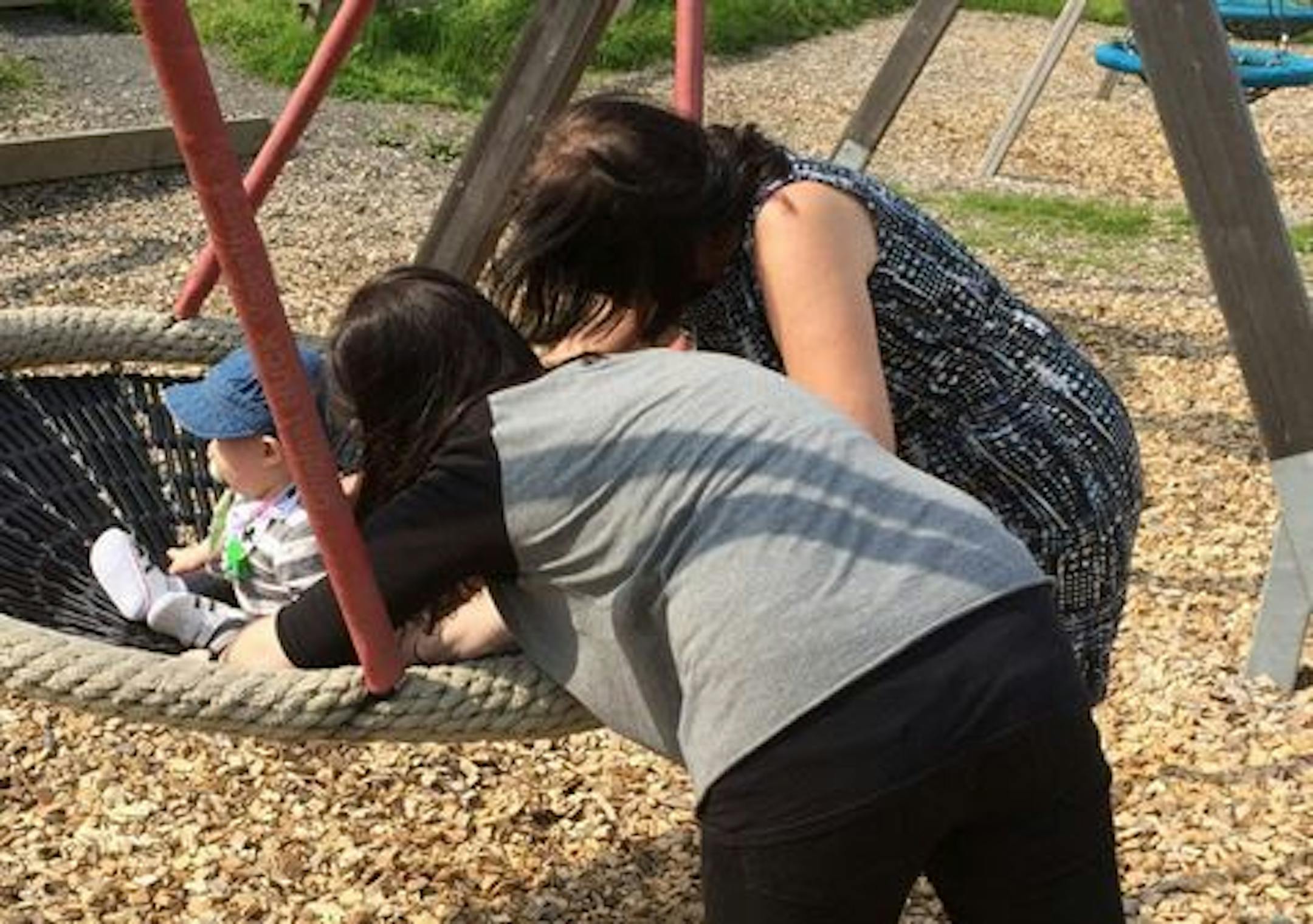 A young Swedish mother, foreground, with her child and and her mother, who asked not to be identified, play with the child on a swing in Gothenburg, Sweden Sunday Aug. 16, 2015.