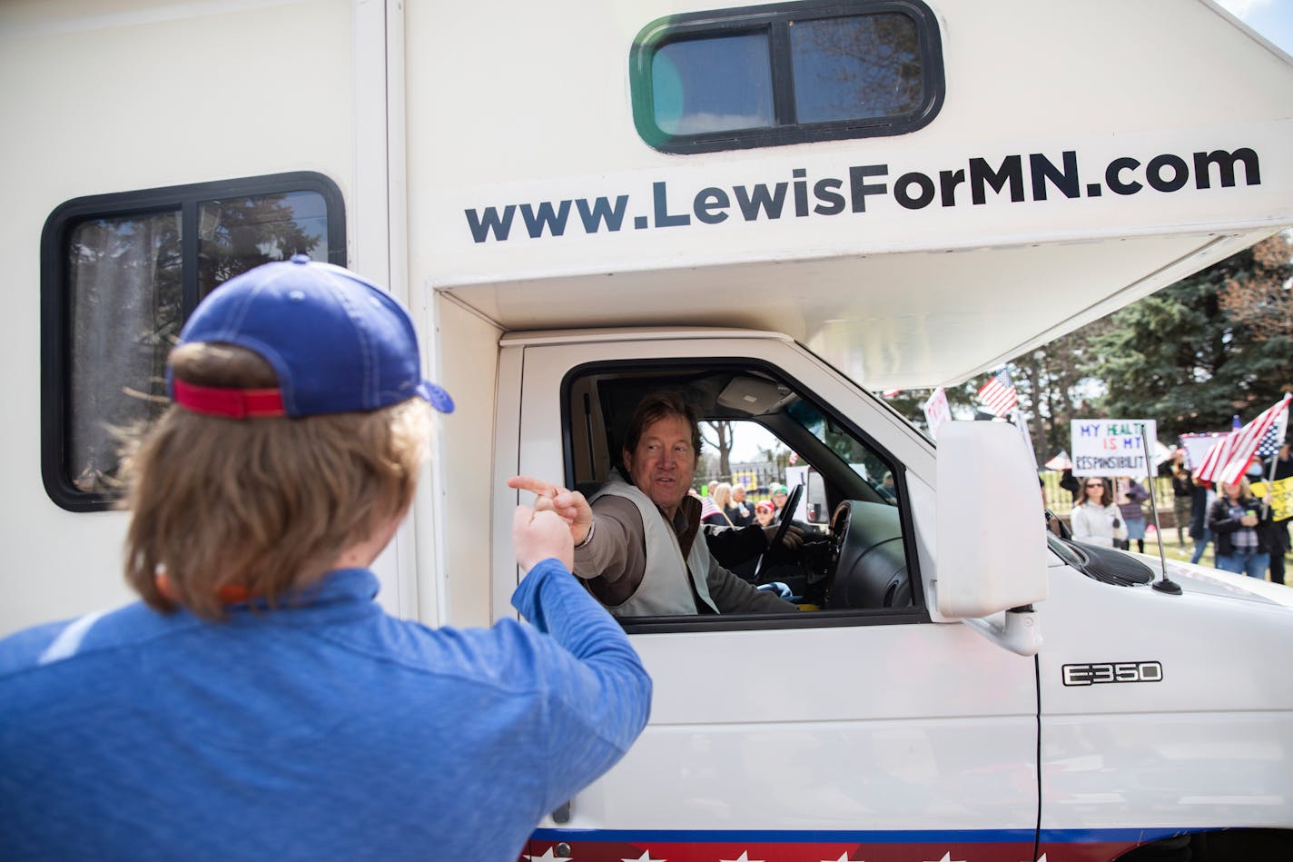 Republican U.S. Senate candidate Jason Lewis fist-bumped and shook hands with protesters from his RV during a "Liberate Minnesota" protest in St. Paul, Minn., on Friday, April 17, 2020.