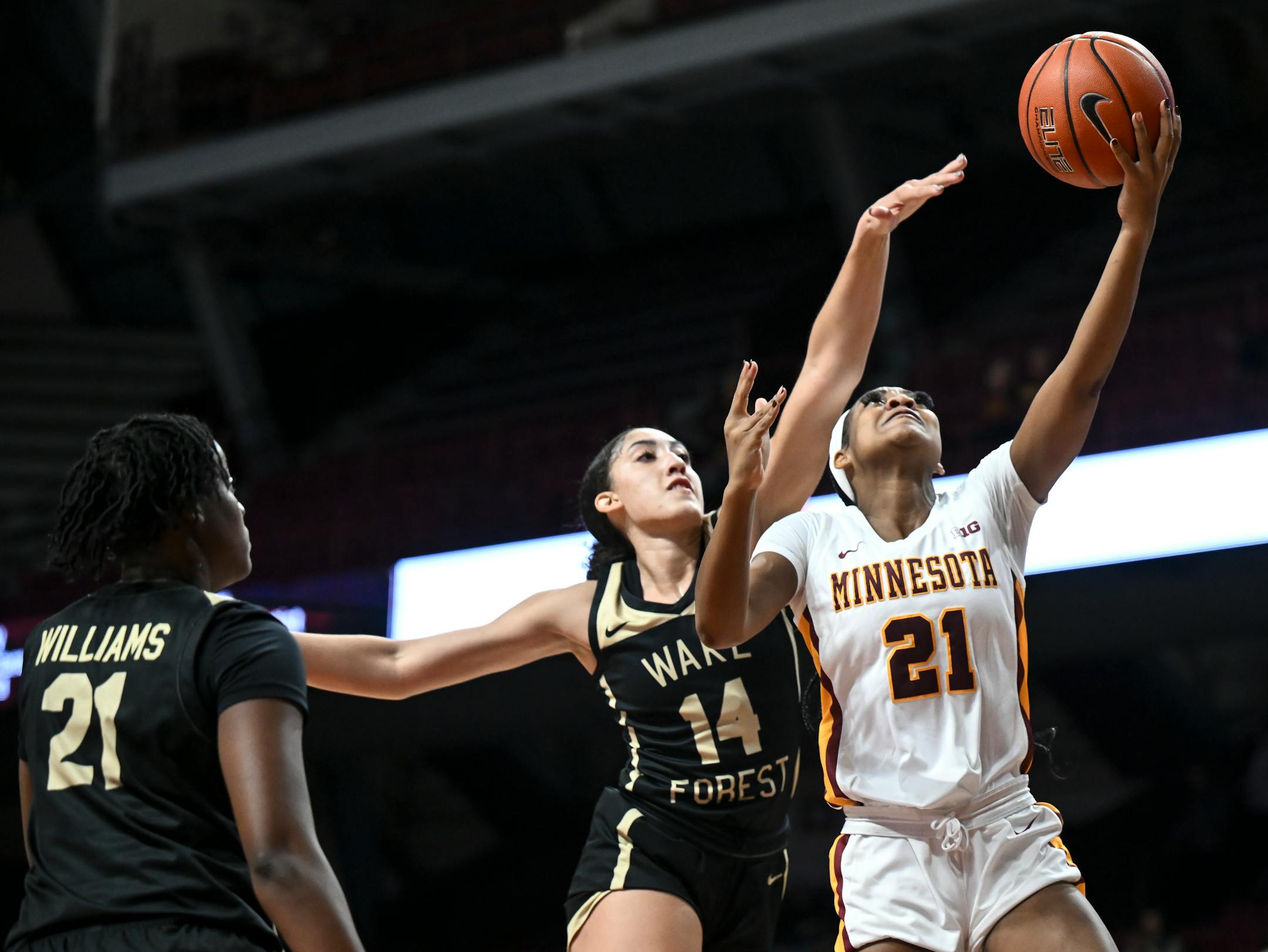 Minnesota Gophers guard Mi'Cole Cayton (21) scores a layup as she's defended by Wake Forest forward Niyah Becker (14) during the first half.