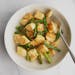 A bowl of cheesy dumplings with asparagus in a lemon-brown butter sauce.
