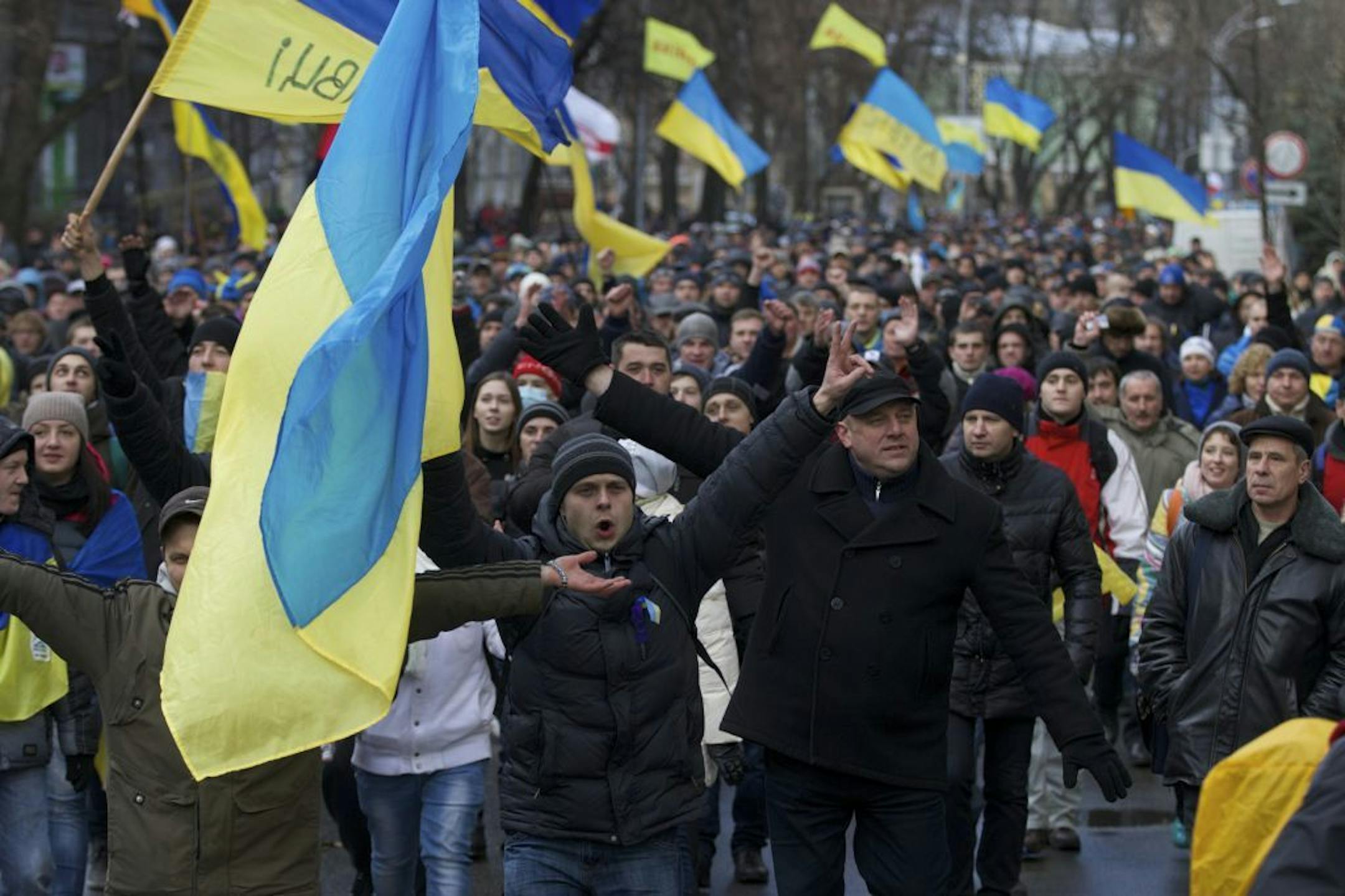 Protesters shout and wave flags marching towards government headquarters in downtown Kiev, Ukraine, on Monday, Dec. 2, 2013.