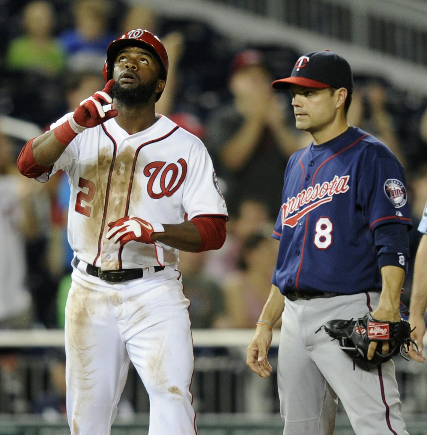 Washington Nationals' Denard Span (2) gestures after he tripled during the sixth inning of the second baseball game of a day-night interleague doubleheader as he stands next to Minnesota Twins third baseman Jamey Carroll (8), Sunday, June 9, 2013, in Washington. (AP Photo/Nick Wass)