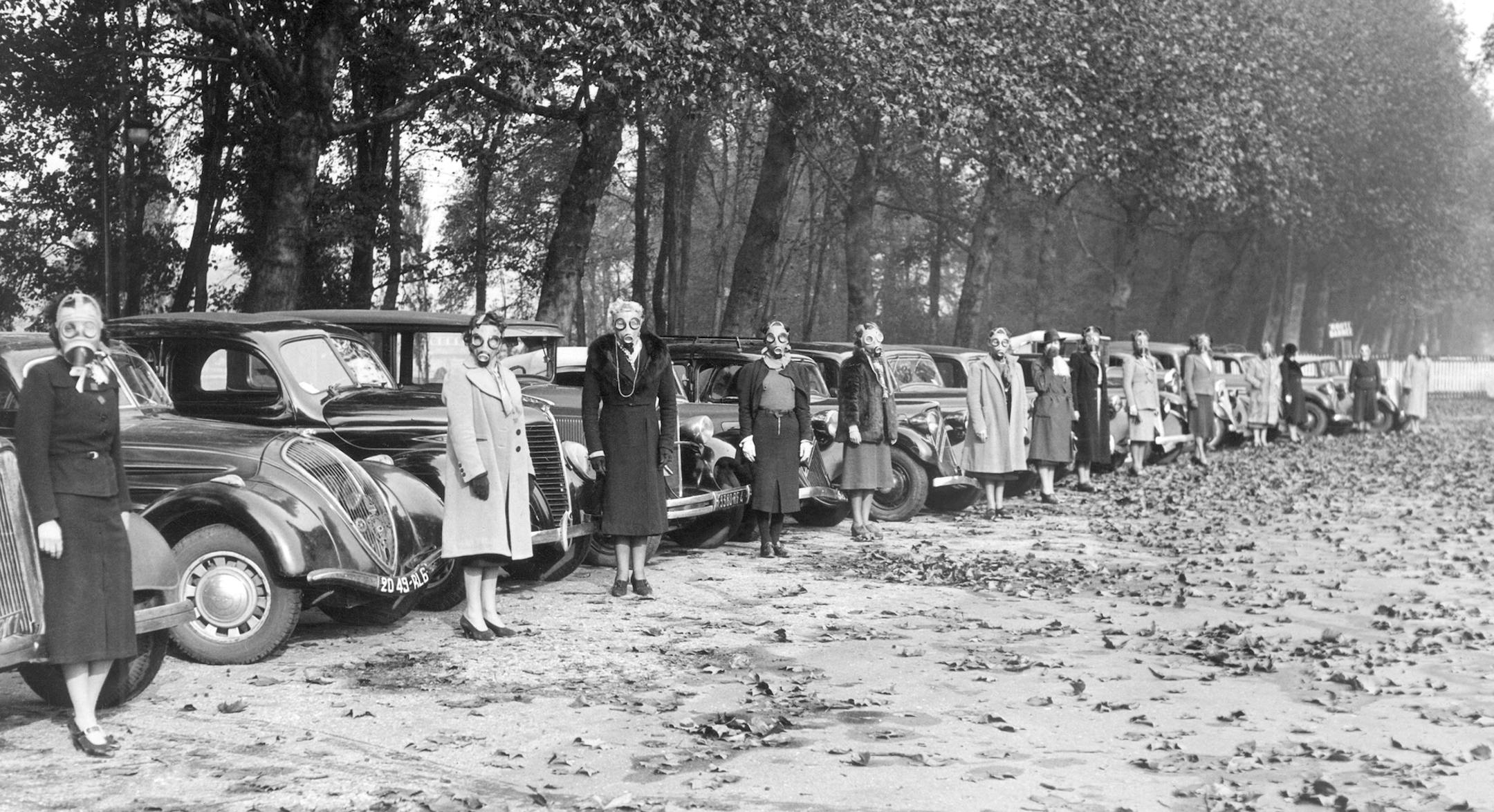 Women volunteers from all walks of life, many of them owners of cars which they have placed at the disposal of A.R.P. service in Paris, undergo regular practice of the duties they may be called to fulfill. Some of the volunteers in front of their cars lined up in a famous Paris Park, the Bois de Boulogne on Oct. 30, 1939. Without, and with their gas mask which they have to wear during the exercises. (AP Photo)