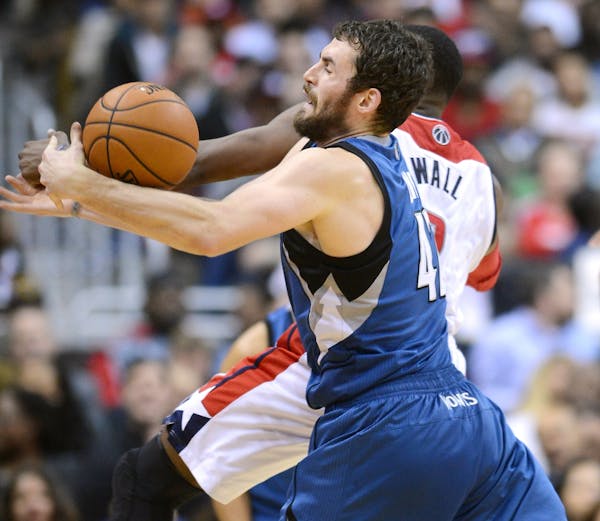 Minnesota Timberwolves power forward Kevin Love (42) and Washington Wizards point guard John Wall (2) collide while going after the ball.