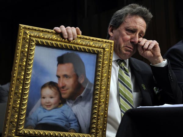 Neil Heslin, the father of a six-year-old boy who was slain in the Sandy Hook massacre in Newtown, Conn., in December, wipes his eye while testifying 