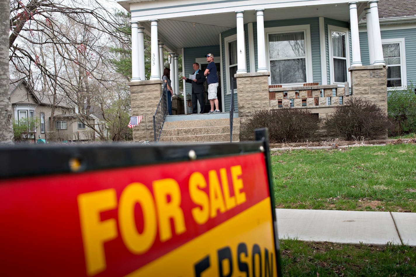 Denny Reichard, an agent with Jim Maloof Realtors, center, talks with potential home buyers Brian Giebelhausen and Lindsay Willing outside a previously owned home in Mackinaw, Illinois, U.S., on Monday, April 21, 2014. Existing home sales in the U.S. fell .2 percent in March, according to the National Association of Realtors. Photographer: Daniel Acker/Bloomberg *** Local Caption *** Denny Reichard; Brian Giebelhausen; Lindsay Willing