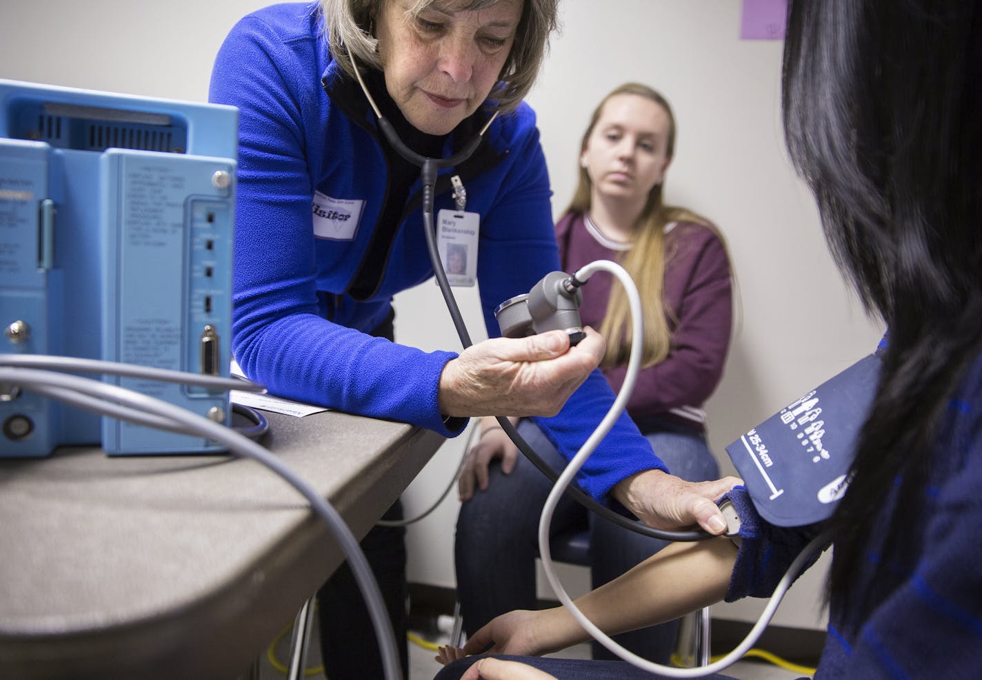 Registered nurse Mark Blankenship measures the blood pressure of a student during a health screening by Allina Health at Champlin Park High School on Tuesday, January 20, 2015. ] LEILA NAVIDI leila.navidi@startribune.com / BACKGROUND INFORMATION: An innovative teen screening program at Anoka-Hennepin schools will be adding mental health screening questions to these health screenings in an attempt to identify and address growing levels of anxiety and depression.