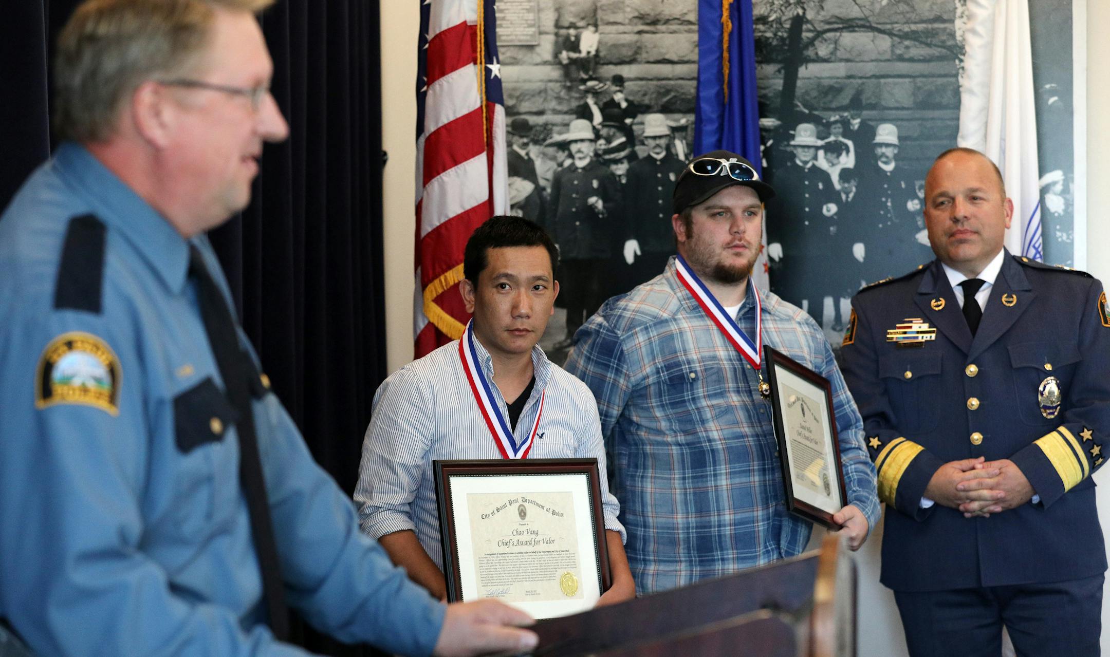 Saint Paul police officer Tom Reis, left, recounted how Chao Vang and Daniel Miller, who while working as security guards for WalMart, assisted him in apprehending a knife-wielding shoplifting suspect as St. Paul Police Chief Todd Axtell stood nearby. ] ANTHONY SOUFFLE ï anthony.souffle@startribune.com St. Paul police held a ceremony to celebrate officers and civilians with their lifesaving awards Wednesday, Sept. 20, 2017 at the Western District's community room in St. Paul, Minn.