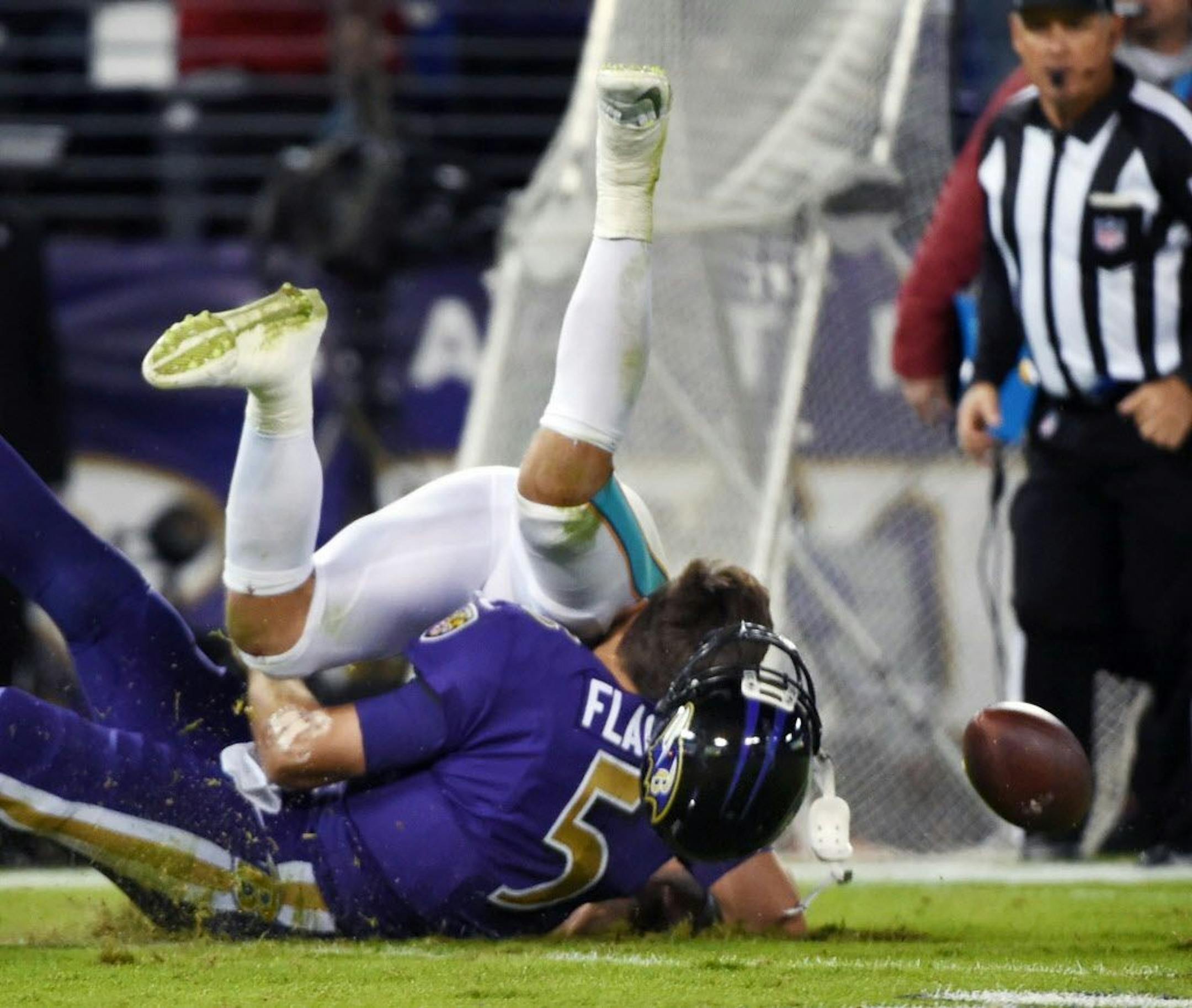 The Miami Dolphins' Kiko Alonso, top, is charged with a personal foul for a hit on Baltimore Ravens quarterback Joe Flacco (5), after he scrambled for 9 yards in the second quarter at M&T Bank Stadium in Baltimore on Thursday, Oct. 26, 2017. Flacco was injured on the play.