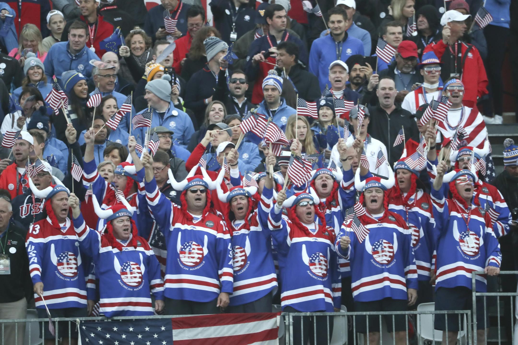 Fans supporting the USA get the crowd going on the first tee as they wait for the players to start play Friday morning.