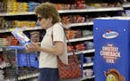 FILE-- In this Friday, July 12, 2013, file photo Jo Mullen picks up a box of Twinkies at Wal-Mart, in Bristol, Pa. The new owners of Hostess have lean