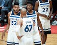 Minnesota Timberwolves center Karl-Anthony Towns (32), forward Taj Gibson (67) and forward Jimmy Butler (23) talked things over between plays in the f