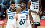 Minnesota Timberwolves center Karl-Anthony Towns (32), forward Taj Gibson (67) and forward Jimmy Butler (23) talked things over between plays in the f