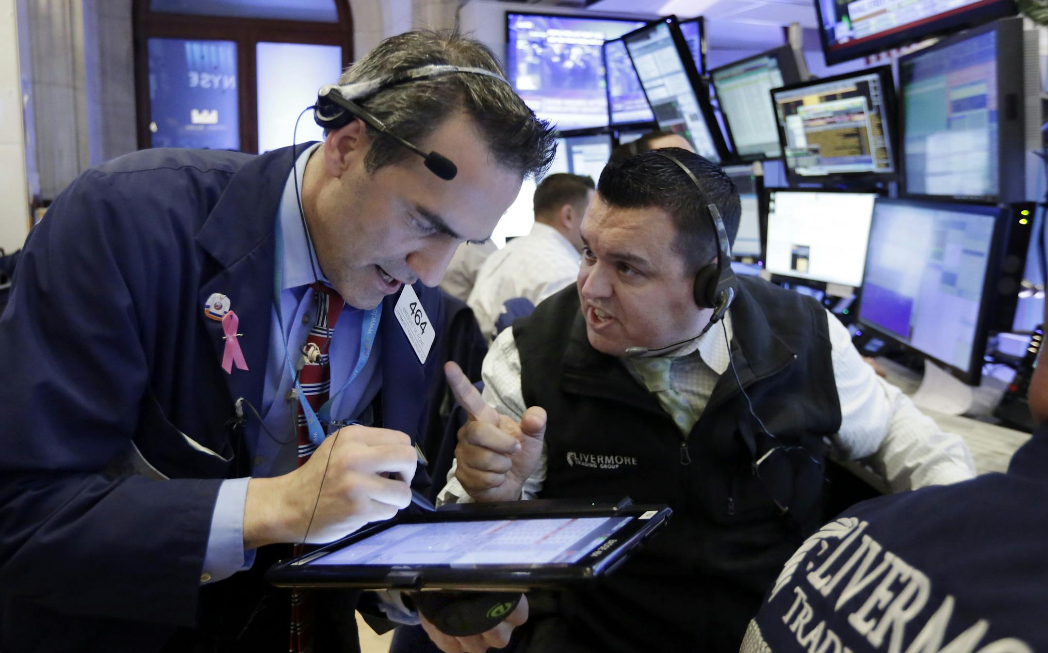 Traders Gregory Rowe, left, and Robert Finnerty work in their booth on the floor of the New York Stock Exchange, Wednesday, Nov. 9, 2016. Stocks are moving solidly higher in midday trading on Wall Street following Donald Trump's upset victory over Hillary Clinton in the U.S. presidential election. (AP Photo/Richard Drew)