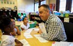 Kindergarten teacher David Boucher made kindergartener Cedrianna laugh as they read together during class at Folwell School, Performing Arts Magnet Sc