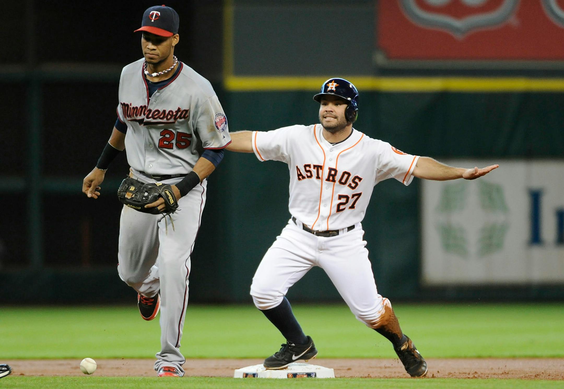 Houston Astros' Jose Altuve (27) signals safe after a catching error on Minnesota Twins shortstop Pedro Florimon (25) on what would have been a force out in the first inning of a baseball game Wednesday, Sept. 4, 2013, in Houston. (AP Photo/Pat Sullivan)