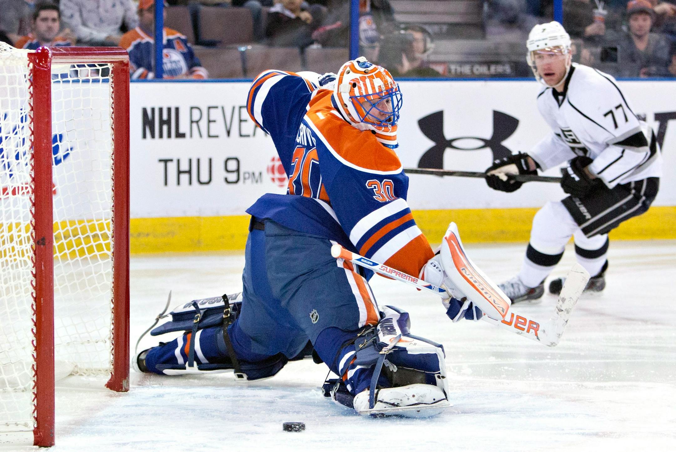 Los Angeles Kings Jeff Carter (77) watches the puck go in the net past Edmonton Oilers goalie Ben Scrivens (30) during first period NHL hockey action in Edmonton, Canada, Sunday March 9, 2014. (AP Photo/The Canadian Press, Jason Franson)
