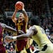Minnesota guard Nate Mason (2) shoots in front of Minnesota center Bakary Konate (21) and Purdue forward Caleb Swanigan in the first half of an NCAA c