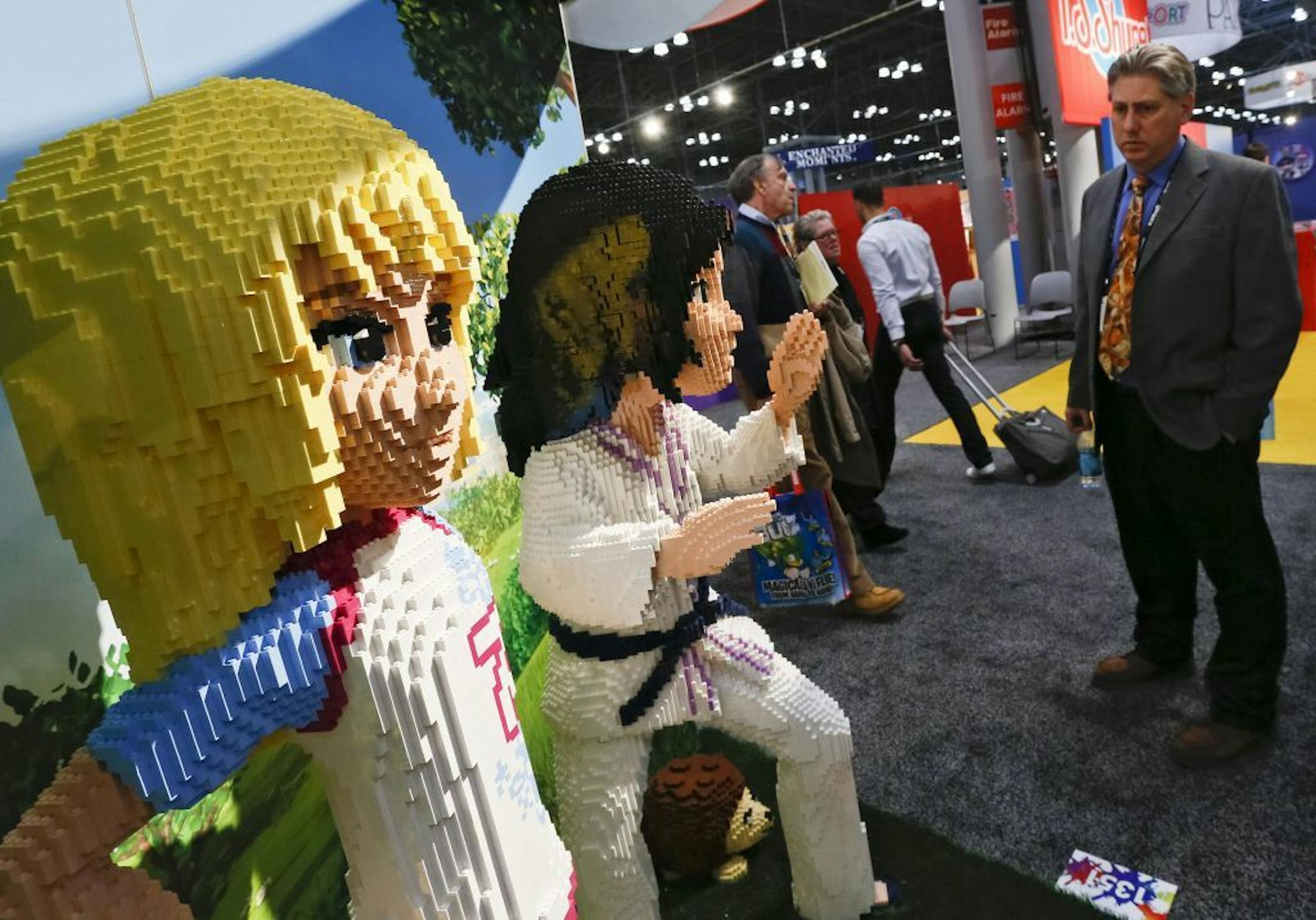 Attendees of the American International Toy Fair view the work of LEGO Master Builders who created 6-foot tall figures, on Sunday, Feb. 10, 2012, in New York.