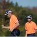 Bernhard Langer, left, and his son Jason Langer pump their fists after the elder Langer made his putt on the 12th green during the first round of the 
