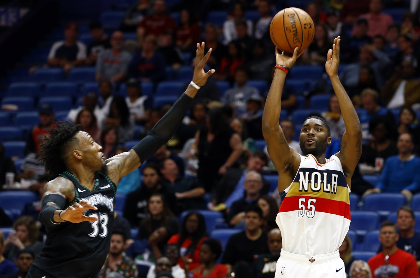 New Orleans Pelicans guard E'Twaun Moore (55) shoots as Minnesota Timberwolves forward Robert Covington (33) tries to defend during the second half of an NBA basketball game, Monday, Dec. 31, 2018, in New Orleans. (AP Photo/Butch Dill)