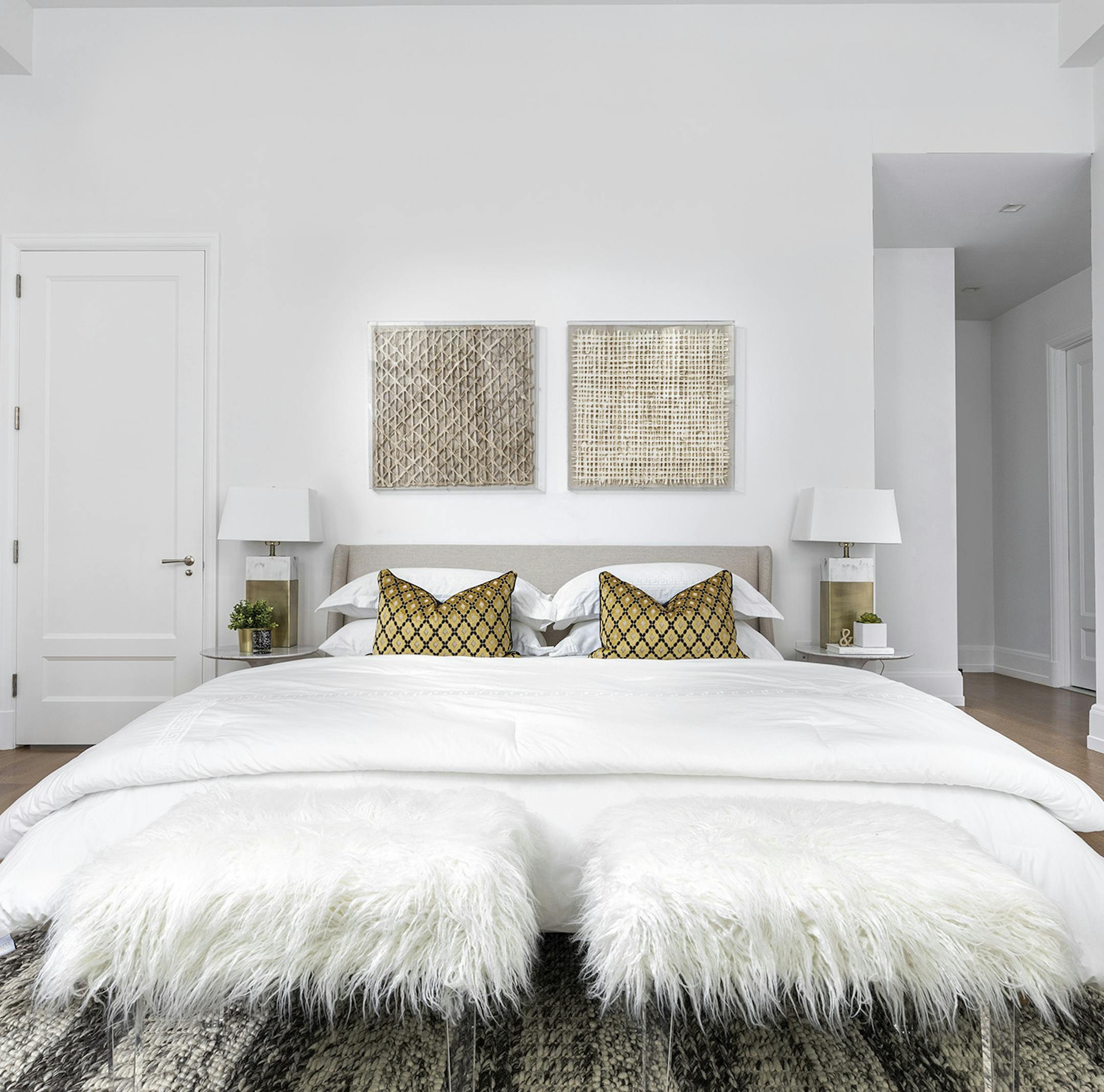Two faux fur stools add texture to this bedroom.