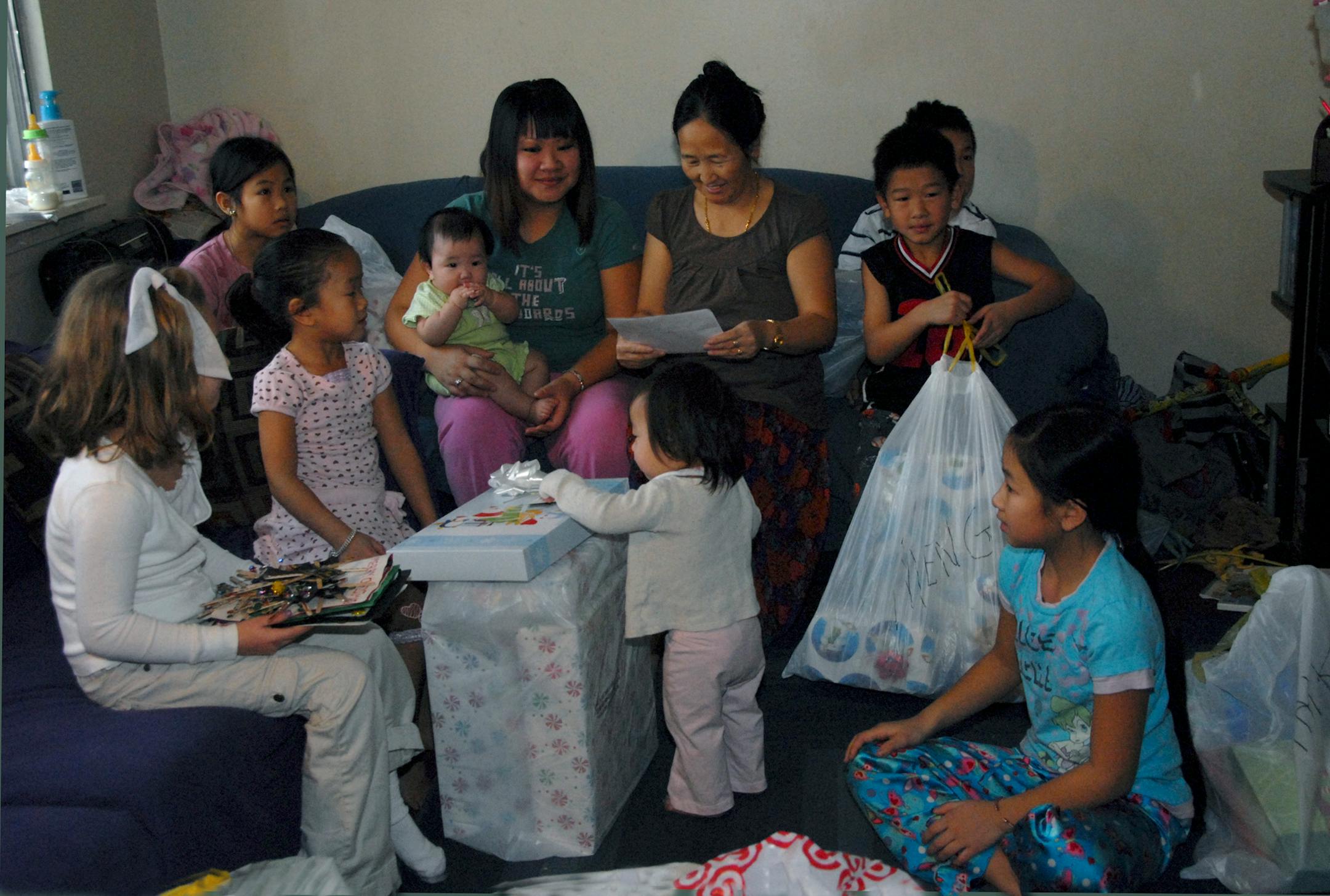 Bailey Haataja, 6, left, sat beside May Yang, 6, as members of the Yang family received presents from Judi Schulz, Bailey's grandmother. Bailey held handmade ornaments from the Yang family. Bailey wanted to give May a "Hello Kitty" bag just like the one she'd received last year.