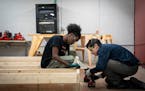 Students Abdullahi Mohamed and Aaron Caldwell work together to screw in floor joists during a construction class at Lake Street Works on Tuesday Febru