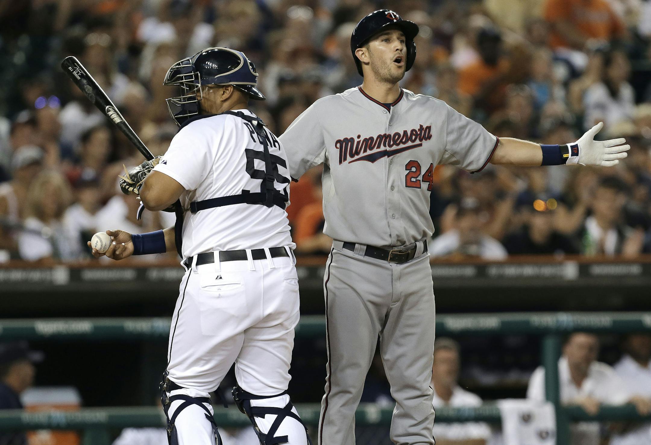 Minnesota Twins' Trevor Plouffe (24) reacts to being called out on strikes by first base umpire Jordan Baker as Detroit Tigers catcher Brayan Pena (55) heads to the dugout in the fifth inning of a baseball game in Detroit, Tuesday, Aug. 20, 2013. (AP Photo/Paul Sancya) ORG XMIT: MIN2013082020371177