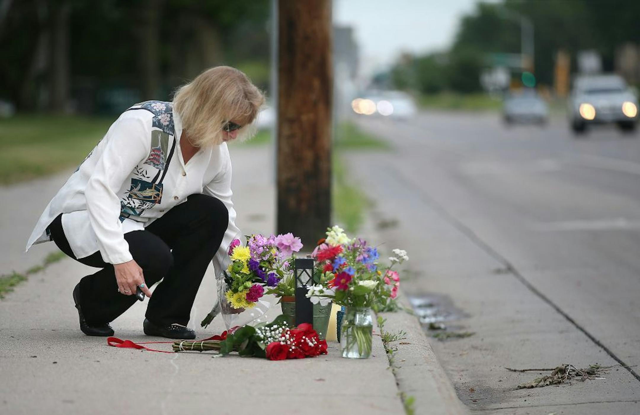 A woman laid flowers Thursday morning at the scene where Philando Castile was shot by a police officer Wednesday night in Falcon Heights.