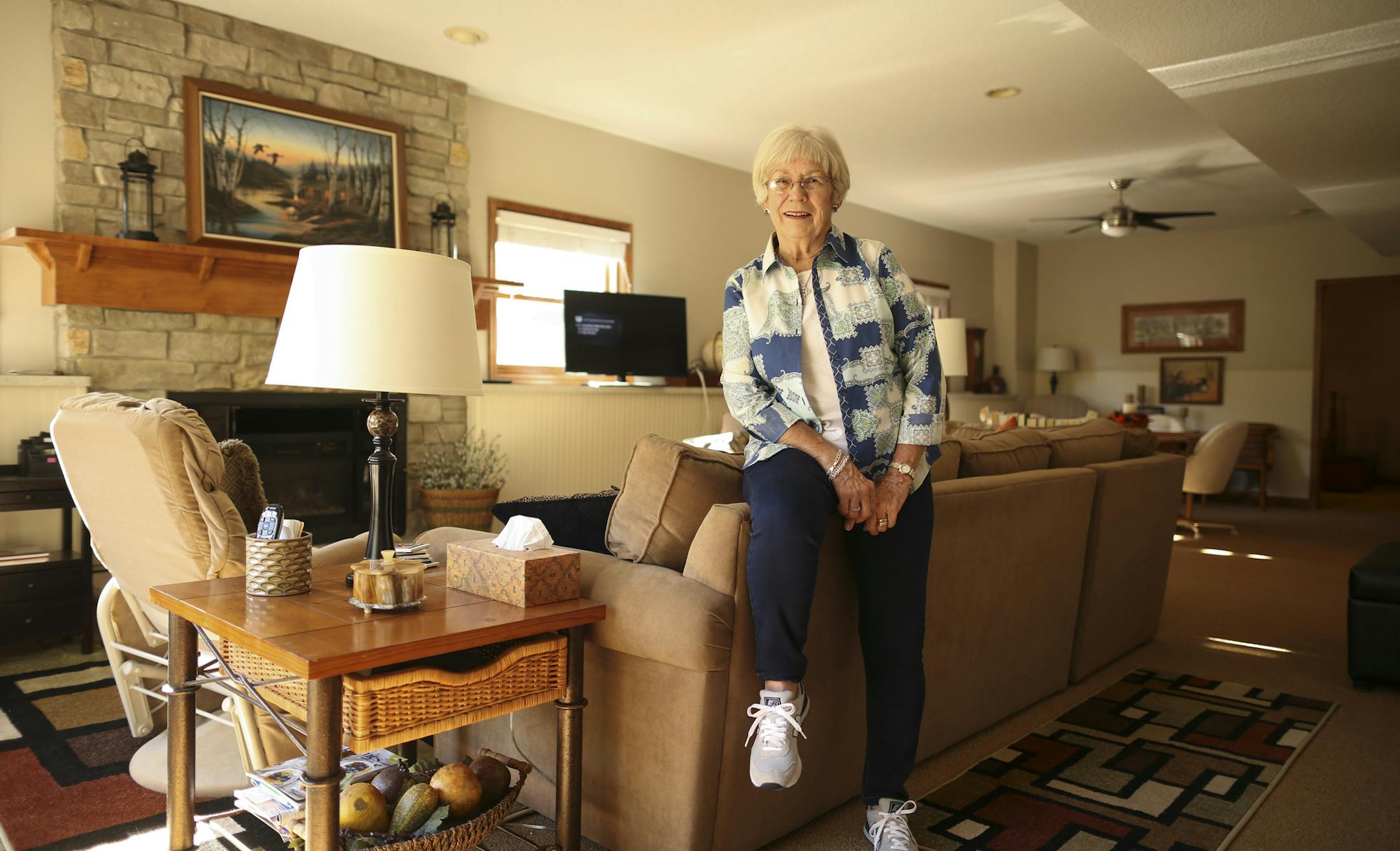 Jan McCabe sits in her garden-level apartment in the home of her daughter Joan Nelson and Joan's husband, Reed. McCabe's new apartment includes a spacious living room with plenty of light for doing her artwork, a full kitchen, bath, laundry room and sewing nook. She also has her own patio and garage stall.