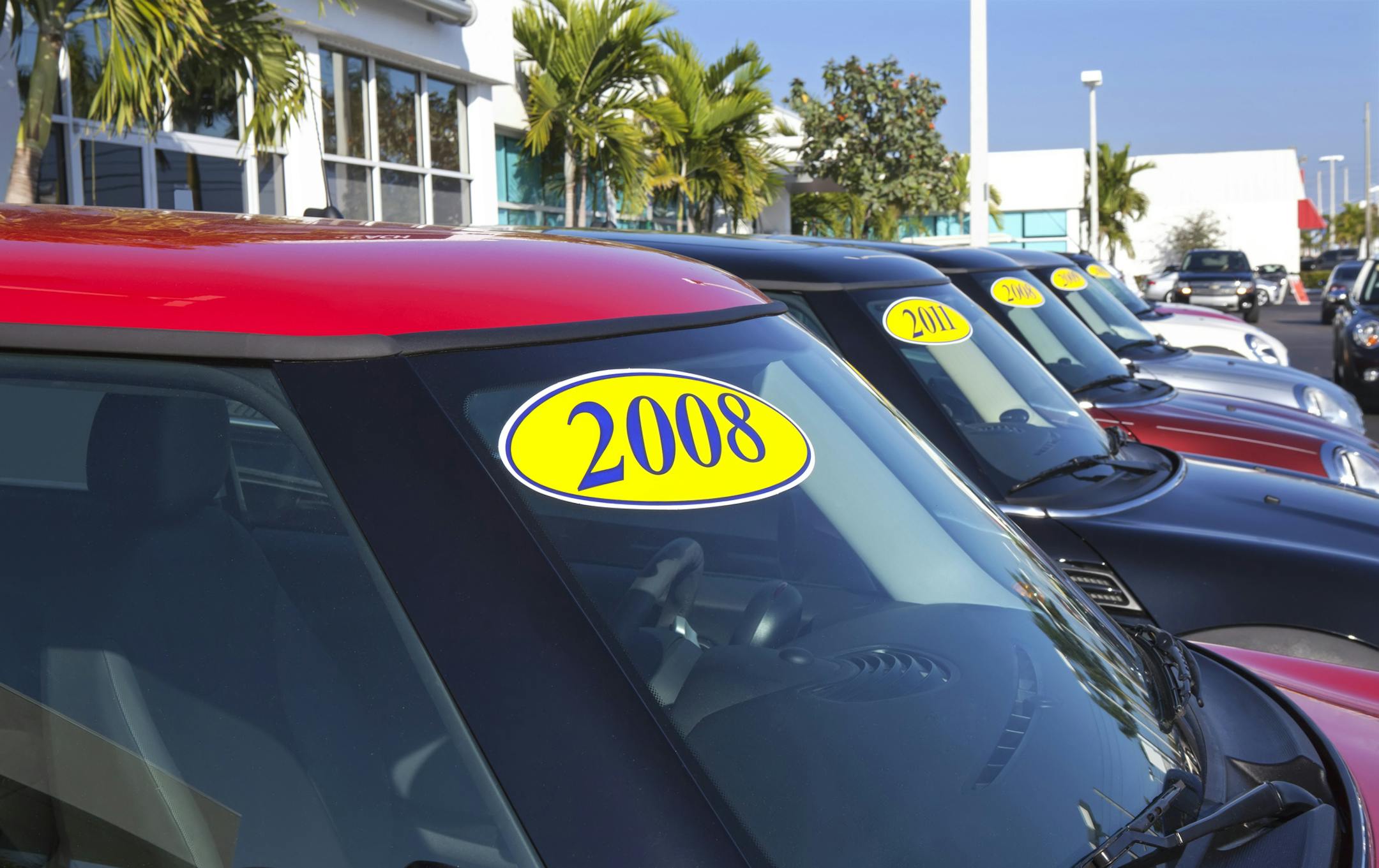 "West Palm Beach, USA - February 24, 2012: used Mini Cooper cars for sale on a car lot with bright yellow stickers with the year of the car"