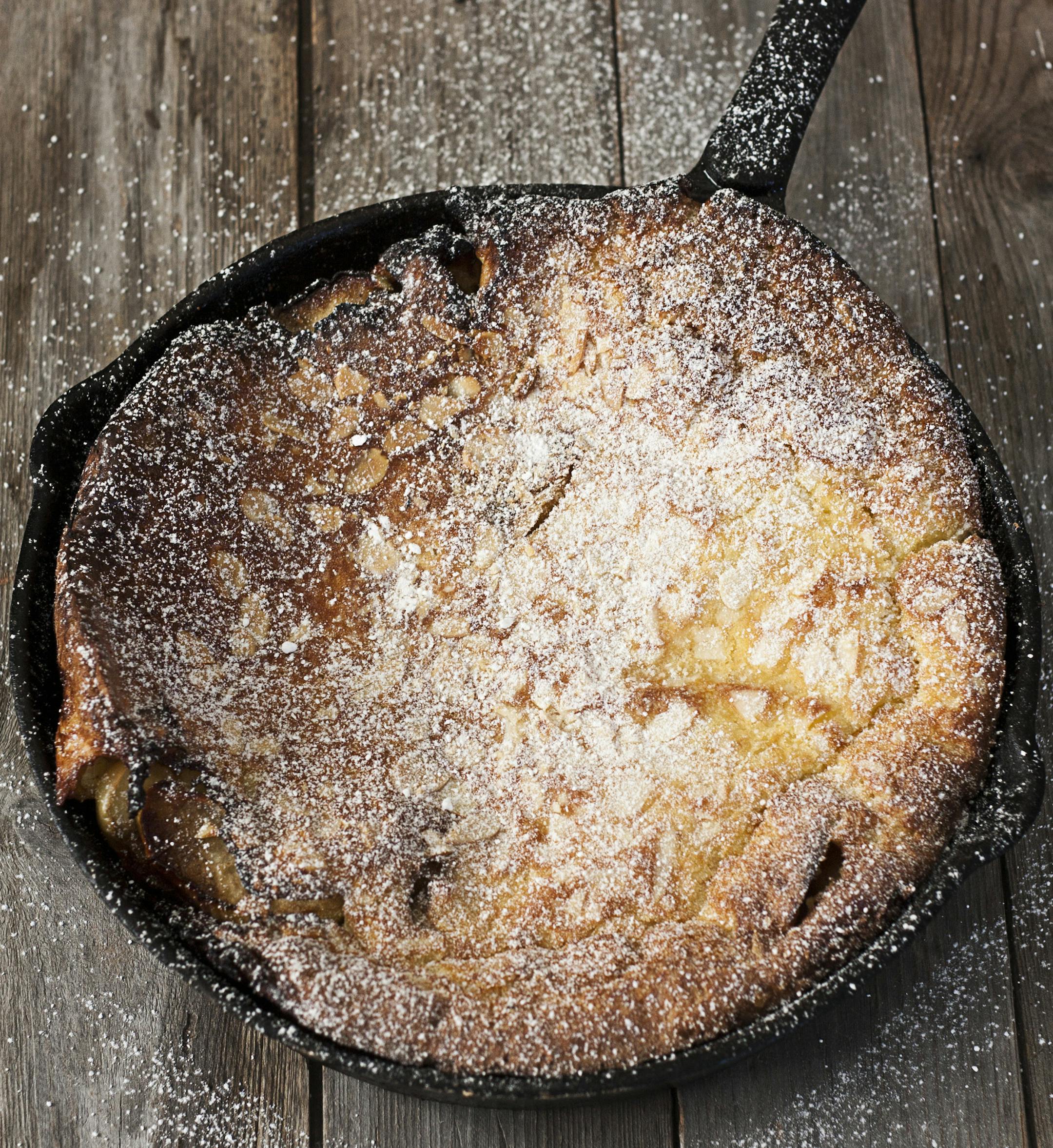 Big dutch baby pancake on iron pan, dusted with powdered sugar. istock photo
