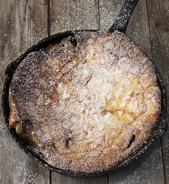 Big dutch baby pancake on iron pan, dusted with powdered sugar. istock photo
